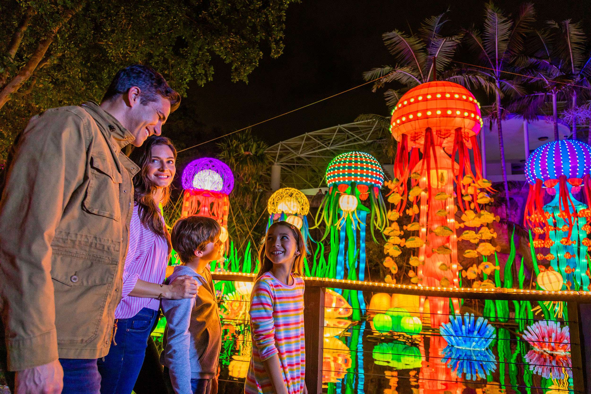 Family walks by display of glowing jelly fish art