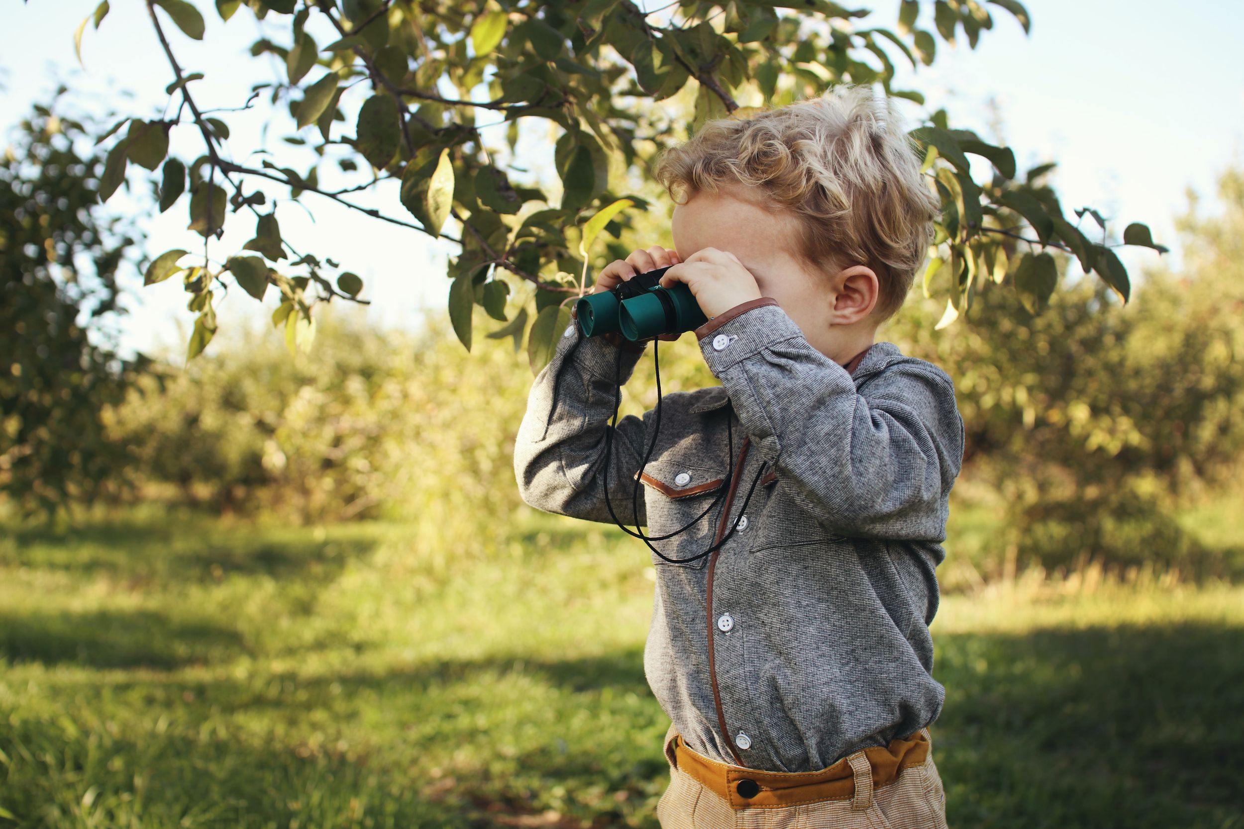 Young boy looks through binoculars