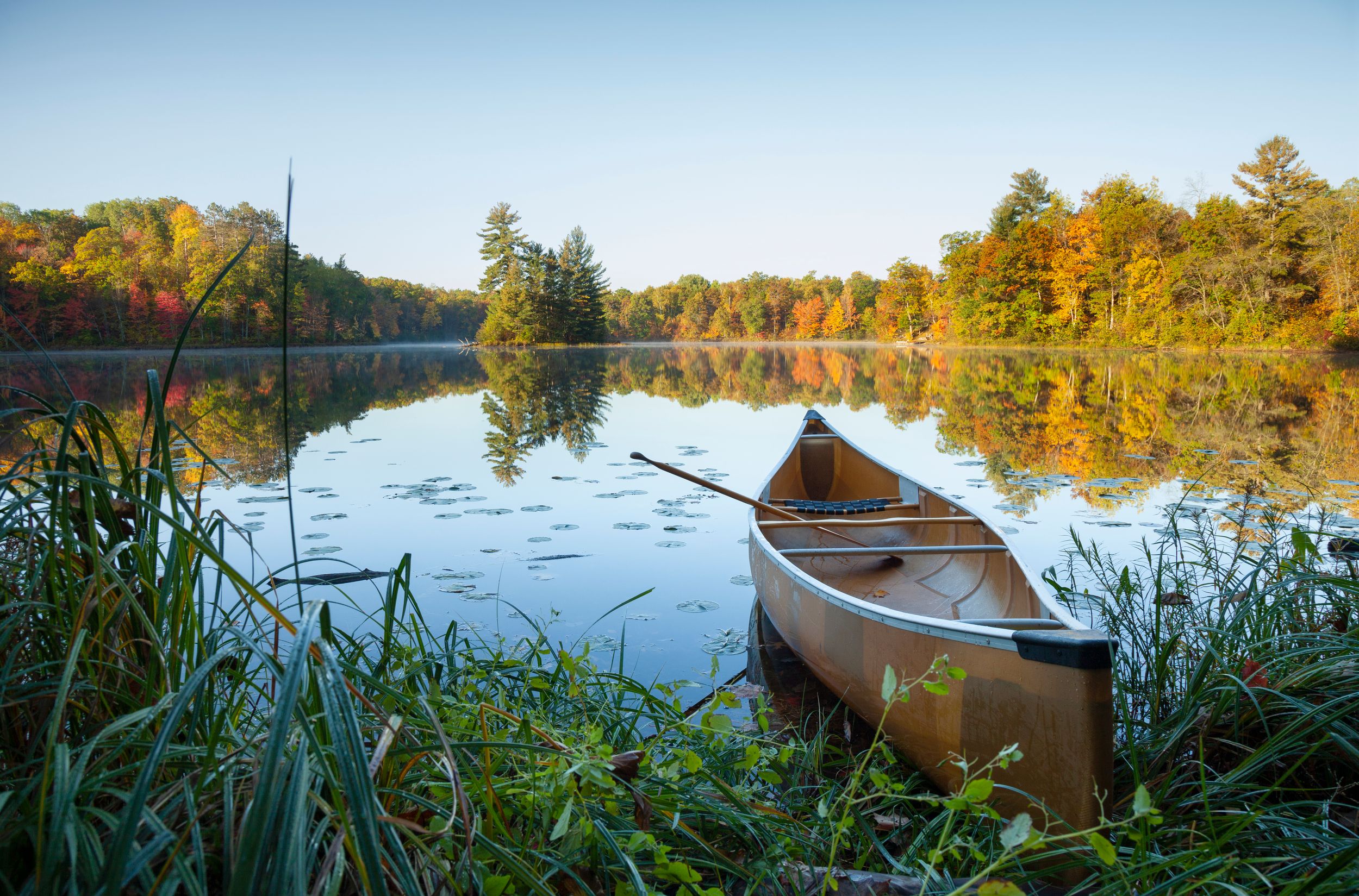 Canoe sits on the bank of a small lake
